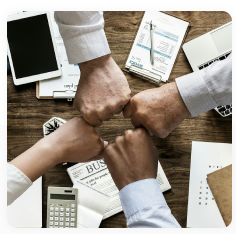 Team fist bump over a desk